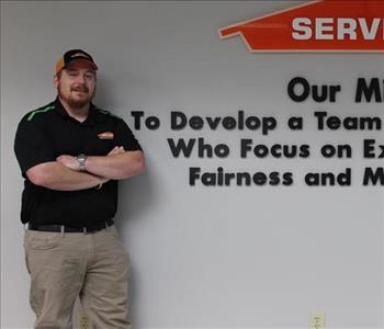 Tech standing in front of our mission statement