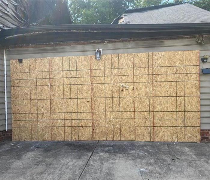 A garage with fire damage being boarded up